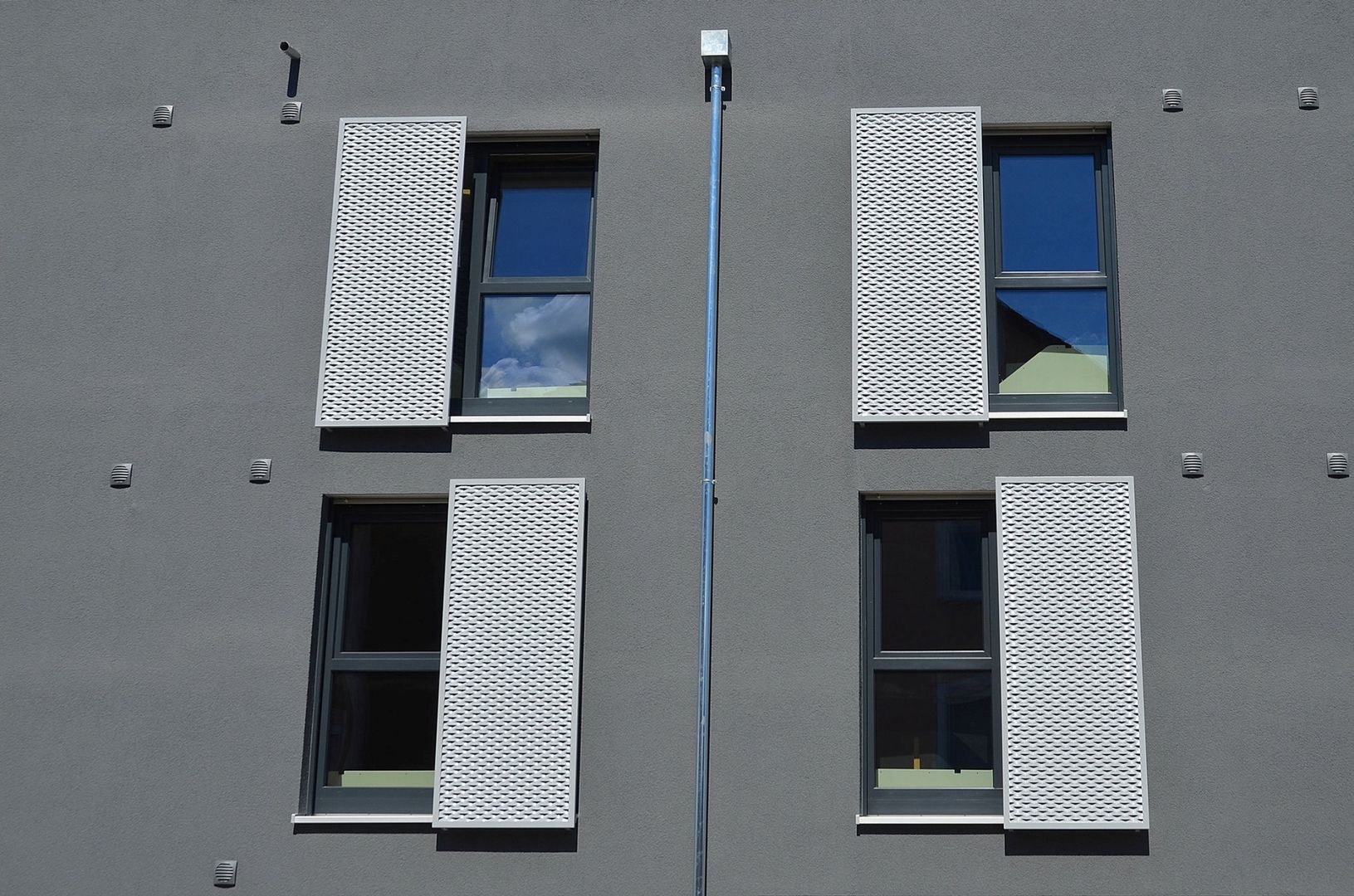 Graue Hauswand mit Fenstern